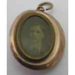 A mourning locket with old photograph, the glass hinged compartment has chips.