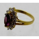 An unmarked ring set with amethyst coloured stone and surrounded by white stones, size L.