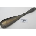 A Chinese white metal shoe horn, embossed with a dragon and bamboo on the reverse side,