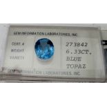 A cased blue oval topaz, 6.33cts, 12mm x 9,90mm x 6.