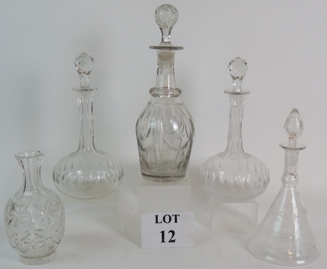 Four cut glass decanters and a cut glass carafe, tallest is 33cm.