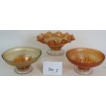 Three glass orange carnival glass bowls with moulded floral decoration, largest 22cm diameter.