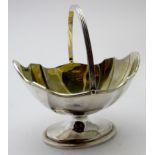 A silver sugar basket with spring handle and pedestal base, gilded interior, London 1894, makers TB,