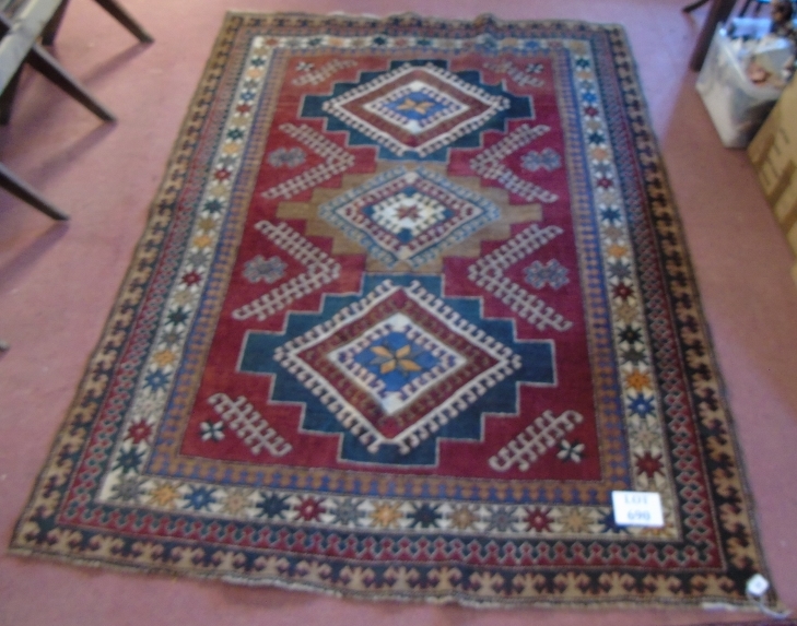 A Caucasion rug with three diamond motifs to center surrounded by a four layer border. - Image 2 of 3