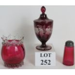 A flash cut Cranberry glass lidded urn decorated with vine leaves, 22cm tall,