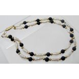 A freshwater pearl and black bead bracelet.