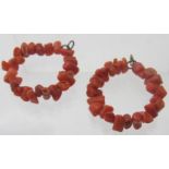 A pair of coral hoop earrings.