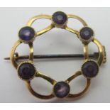 A 15ct gold circular openwork brooch set with six circular amethysts,