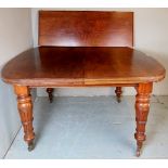 A Victorian carved mahogany extending oval dining table with one additional leaf and terminating on