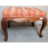 A 19th Century carved oak framed footstool with a floral upholstered top.