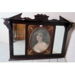 A decorative oak framed over mantle mirror with a central inset oval print depicting a portrait