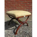 A Regency mahogany X frame stool upholstered in a cream fabric.