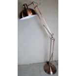 A contemporary freestanding angle poise adjustable lamp with a copper finish.