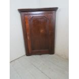 A Georgian oak corner cupboard with a panelled door. Condition report: In good overall condition.