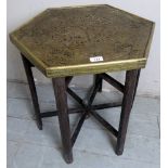 A decorative eastern hexagonal brass topped folding side table with chamfered legs.