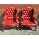 A Pair 20th century red leather deep buttoned wingback chairs with carved ball and claw