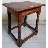 An 18th century oak joint stool , with a double planked top over turned legs an stretchers,