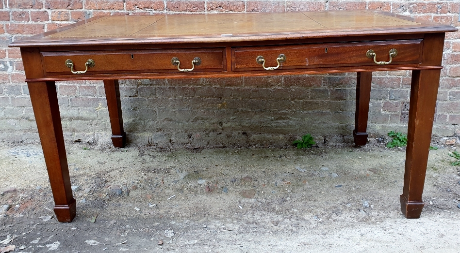 A Large Edwardian style desk with an inset tan leather top over two long drawers and tapered legs.