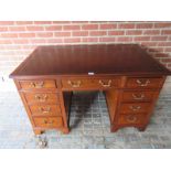 A good quality mahogany pedestal desk with an inset burgundy tooled leather top over an assortment
