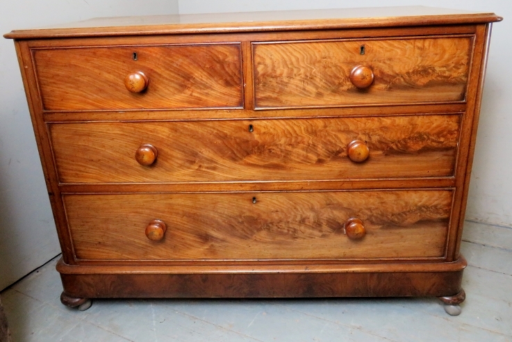 A Victorian mahogany low chest of two short over two long flame mahogany drawers with bun handles