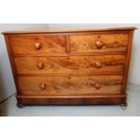 A Victorian mahogany low chest of two short over two long flame mahogany drawers with bun handles