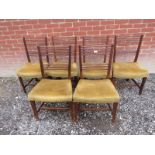 A set of six Georgian oak framed dining chairs upholstered in a gold material.