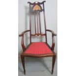 An Edwardian high back inlaid mahogany elbow chair with a red upholstered seat.