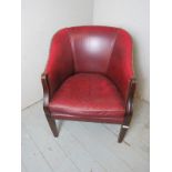 A 20th Century mahogany framed tub chair upholstered in a burgundy leather with brass studwork.