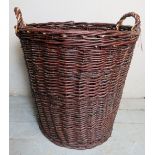 A large decorative whicker log basket with carry handles.