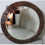 A contemporary circular copper effect wall mirror with embossed decoration.