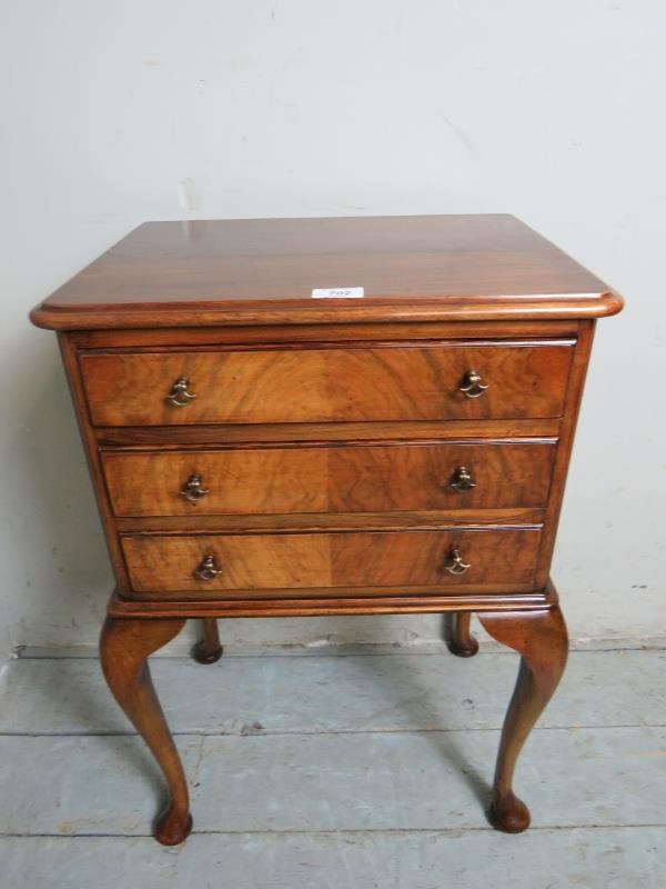 A small pretty walnut side table / bedside with three drawers over cabriole legs.