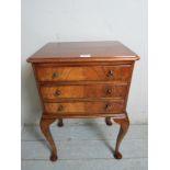 A small pretty walnut side table / bedside with three drawers over cabriole legs.