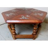 An unusual decorative hexagonal oriental coffee table with a brown leather top decorated with fish.