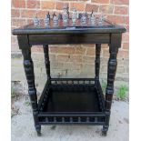 An Edwardian ebonised side table with a later inset leather chess board to top complete with a set