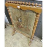 A 19th Century turned walnut framed fire screen with inset fabric panel depicting figures in a