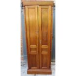 An unusual tall and narrow 20th century two door cupboard with panelled design.