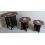 A trio of carved hardwood eastern folding side tables with intricate carving and having shaped tops