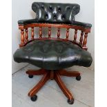 A 20th Century captain's swivel office / desk chair upholstered in a green button back leather,