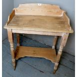 A Victorian pine washstand with a raised gallery rail to top over turned tapering legs.