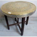 An early 20th Century eastern brass topped circular side table with intricate embossed decoration