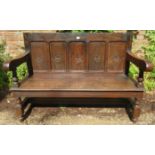 Oak pew, 18th Century panelled back over a planked seat with heavy carved arms and legs. Very solid.
