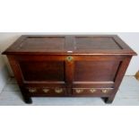 A Georgian oak mule chest with panelled front and sides over two drawers to base with decorative