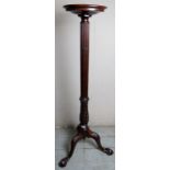 A 19th Century carved mahogany torchere stand with a reeded and floral carved column over splayed