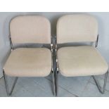 A pair of post war 'Giroflex' office armchairs with cream upholstery over chrome legs.