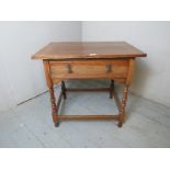 A 19th Century oak lowboy side table with a long single frieze drawer over turned legs and lower