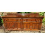 A large Victorian inlaid oak sideboard with a raised back gallery rail over a carved frieze and two