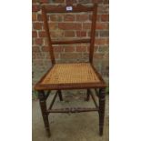 A 19th century mahogany framed occasional chair with a caned seat over a turned stretcher and legs.