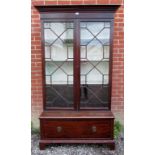 A large Edwardian mahogany display cabinet with glazed double doors to top revealing internal