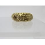 A heavy 18ct yellow gold ring intertwined with a serpent showing his forked tongue and fangs,