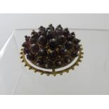 An 18ct yellow gold circular domed garnet cluster brooch.